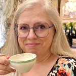 A picture of Susan Langley holding a cup of tea and smiling